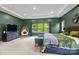 Relaxing primary bedroom with natural light, green accent wall and a cozy sitting area at 20307 Creek Bend Edge Ct # 10, Matthews, NC 28105