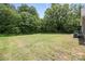 View of the spacious backyard with mature trees providing privacy and shade, ideal for outdoor activities at 209 S Gregory St # 3, Lancaster, SC 29720