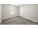 A calm bedroom has neutral walls and carpeting, a window, and closet door at 209 S Gregory St # 3, Lancaster, SC 29720