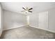 A bright bedroom has neutral carpeting, a ceiling fan, and a closet door at 209 S Gregory St # 3, Lancaster, SC 29720