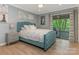 Stylish bedroom with a tufted headboard, balcony access, and hardwood floors at 212 W 10Th St # 3, Charlotte, NC 28202