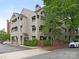 Multi-story condo building with stacked covered patios and mature landscaping and brick retaining wall at 212 W 10Th St # 3, Charlotte, NC 28202