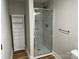 Modern bathroom featuring a tiled shower with glass door, linen cabinet, and wood grain vinyl flooring at 216 N Vance St, Gastonia, NC 28052