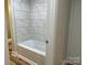Modern bathroom featuring a tiled shower/tub, new wood flooring, and clean finishes at 216 N Vance St, Gastonia, NC 28052