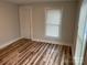 Neutral bedroom with a window and a closet, featuring wood grain vinyl flooring at 216 N Vance St, Gastonia, NC 28052