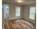 A bright, neutral bedroom with two windows and wood grain vinyl flooring with an attached bath at 216 N Vance St, Gastonia, NC 28052