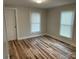 Well-lit bedroom featuring two windows, new wood flooring, and neutral paint at 216 N Vance St, Gastonia, NC 28052