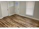 Bright bedroom with a door, window, new wood flooring, and neutral paint at 216 N Vance St, Gastonia, NC 28052