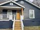 Charming exterior showcasing a blue home with a welcoming yellow door and wooden steps at 216 N Vance St, Gastonia, NC 28052