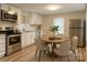 Bright kitchen with white cabinets, stainless steel appliances, and a cozy breakfast nook with seating for four at 216 N Vance St, Gastonia, NC 28052