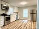 Modern kitchen featuring stainless steel appliances, ample cabinet space, and new wood flooring at 216 N Vance St, Gastonia, NC 28052