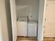 Bright laundry area featuring a stacked washer and dryer in a closet with wood grain vinyl flooring at 216 N Vance St, Gastonia, NC 28052