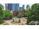 Brick building with trees and a fountain in front of skyscrapers in an urban setting at 224 N Poplar St # 24, Charlotte, NC 28202