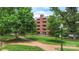 Brick building from path through yard with mature trees and landscaping at 224 N Poplar St # 24, Charlotte, NC 28202