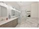 Elegant bathroom featuring double vanity, marble finishes, a glass-enclosed shower, and a soaking tub at 229 N Church St # 204, Charlotte, NC 28202