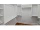 Well organized walk-in closet featuring white shelving and ample storage space, plus hardwood floors at 229 N Church St # 204, Charlotte, NC 28202