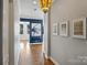 Inviting hallway featuring hardwood floors, elegant lighting, neutral paint and framed artwork, leading to an open living space at 229 N Church St # 204, Charlotte, NC 28202