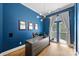 Well-lit office with striking blue walls, modern light fixture, and ample workspace with hardwood floors at 229 N Church St # 204, Charlotte, NC 28202