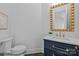 Powder room featuring a navy vanity with a brass mirror and dark wood floors at 238 Horton Grove Rd, Fort Mill, SC 29715