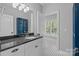 Well-lit bathroom with black granite countertops, classic tile flooring, and white cabinets at 238 Horton Grove Rd, Fort Mill, SC 29715