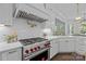 Gourmet kitchen featuring a Wolf range, white cabinetry, marble countertops, and pot filler at 238 Horton Grove Rd, Fort Mill, SC 29715
