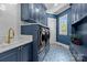 Stylish laundry room with blue cabinets, patterned tile flooring, and modern washer and dryer at 238 Horton Grove Rd, Fort Mill, SC 29715