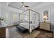 Bright main bedroom featuring a gold canopy bed, tray ceiling, and warm hardwood floors at 238 Horton Grove Rd, Fort Mill, SC 29715