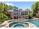A hot tub and pool combination is surrounded by a stone patio and leads to a multi-story home at 238 Horton Grove Rd, Fort Mill, SC 29715