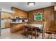 Eat-in kitchen area featuring wood cabinets, tile floors, and a bright window at 2401 Hillside Dr, Newton, NC 28658