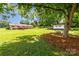Expansive backyard with mature trees, showcasing a covered patio, outbuilding, and outdoor swing, perfect for leisure at 2401 Hoffman St, Gastonia, NC 28054