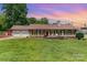 Charming single-story home with a well-manicured lawn, a red front door and a two-car garage at 2401 Hoffman St, Gastonia, NC 28054