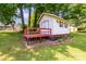 Charming outbuilding featuring a red deck and trim, complemented by a well-maintained lawn and mature trees at 2401 Hoffman St, Gastonia, NC 28054