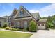 Charming two-story stone home featuring a well-manicured front yard and attached garage at 2414 Madeira Cir, Waxhaw, NC 28173