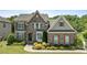 Beautiful two-story stone home with manicured landscaping and charming architectural details at 2414 Madeira Cir, Waxhaw, NC 28173