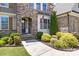 Close up of the entryway featuring a stone facade, blue front door, and lush landscaping at 2414 Madeira Cir, Waxhaw, NC 28173