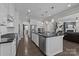 Kitchen with large island, stainless steel appliances, white cabinets, and dark countertops at 2414 Madeira Cir, Waxhaw, NC 28173