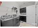 Convenient laundry room featuring modern washer, dryer, utility sink, and cabinet storage at 2414 Madeira Cir, Waxhaw, NC 28173