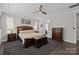 Well-lit main bedroom featuring a ceiling fan, natural light, and wood furniture at 2414 Madeira Cir, Waxhaw, NC 28173