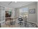 Well-lit office features a large window, modern furniture, and French doors opening to dining area at 2414 Madeira Cir, Waxhaw, NC 28173