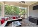 Relaxing screened porch with comfortable seating, patriotic decor, and views of the backyard at 2414 Madeira Cir, Waxhaw, NC 28173