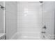 Bright bathroom with white-tiled walls and a bathtub with chrome fixtures at 4005 Easton Ridge Ln, Charlotte, NC 28226