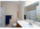 Well-lit bathroom with decorative wallpaper, white countertop, and matching shower curtain at 403 Cherrywood Ln, Albemarle, NC 28001