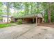Charming single-story brick home with a covered carport and a well-maintained front yard surrounded by mature trees at 403 Cherrywood Ln, Albemarle, NC 28001