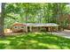 Charming brick home with a well-maintained lawn, mature trees, and covered carport at 403 Cherrywood Ln, Albemarle, NC 28001