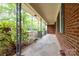 Extended view of the covered porch featuring decorative supports and a brick exterior at 403 Cherrywood Ln, Albemarle, NC 28001