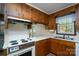 Kitchen with vintage stove, wood cabinets, and bright countertops with a double stainless steel sink at 403 Cherrywood Ln, Albemarle, NC 28001