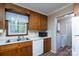 Cozy kitchen leading to laundry area, featuring classic wood cabinetry and bright, clean appliances at 403 Cherrywood Ln, Albemarle, NC 28001