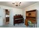 Well-lit home office area with a piano, desk, and view into the kitchen at 403 Cherrywood Ln, Albemarle, NC 28001
