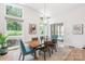 Bright dining area with large windows, wood table, modern chandelier, and seating for six at 4108 Commonwealth Ave, Charlotte, NC 28205