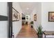 Bright hallway with hardwood floors, white walls, and artwork leading to the living area at 4108 Commonwealth Ave, Charlotte, NC 28205